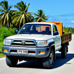 **Image Prompt:** A sturdy, well-maintained Toyota pickup truck driving on a paved road in Funafuti, Tuvalu. The truck is fully loaded with supplies. Palm trees line the road. Clear blue sky. "safe for work", "appropriate content", "fully clothed", "professional photography", "natural proportions"
